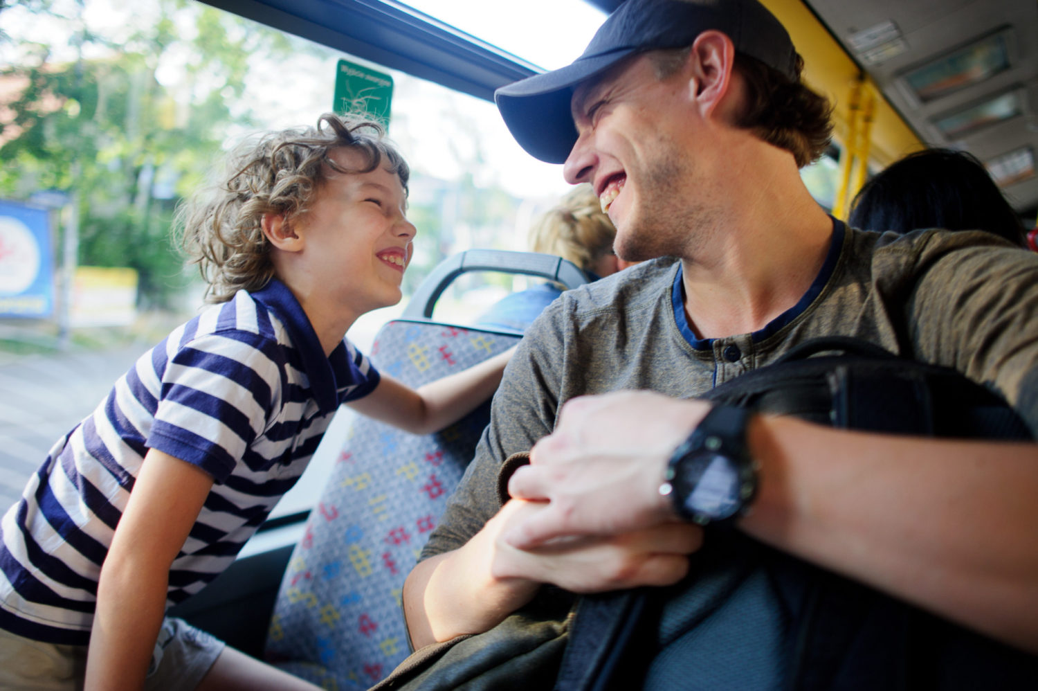 Young man takes the bus together with son.